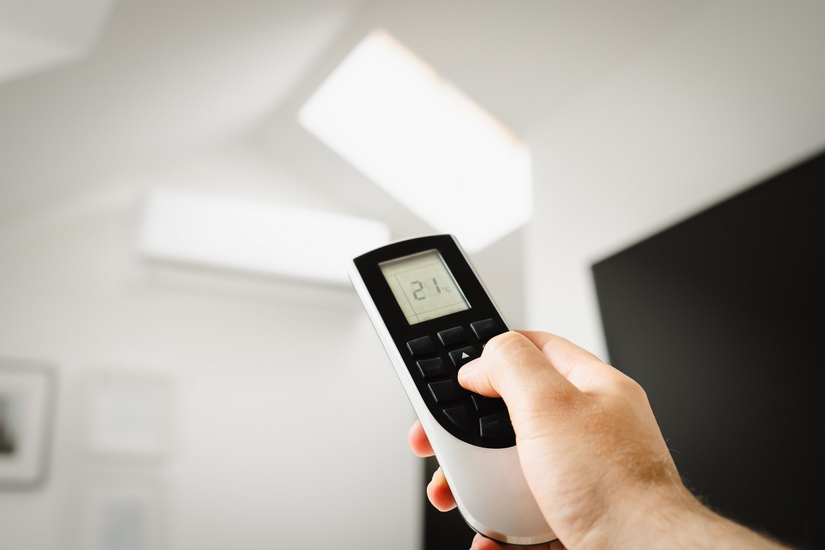 close-up of a person using an air con remote