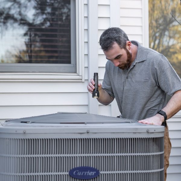 man inspecting an HVAC unit