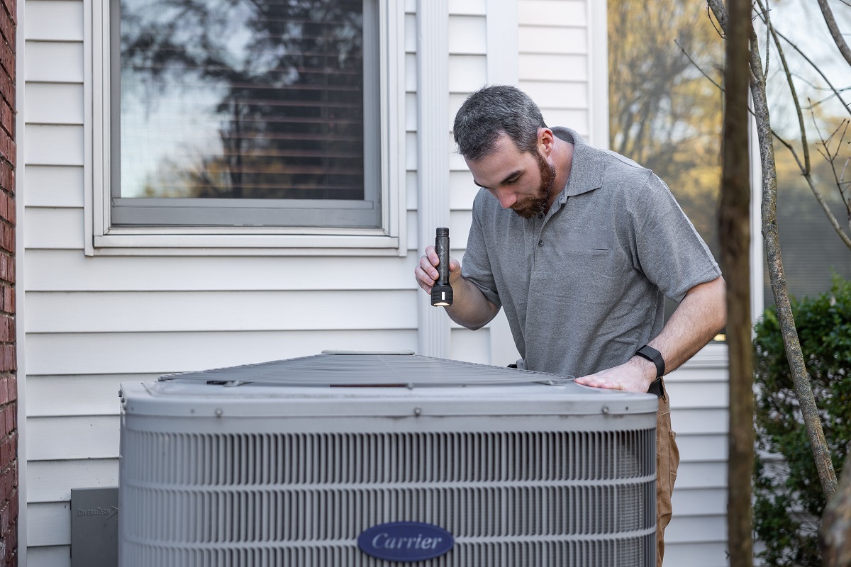 man inspecting an HVAC unit